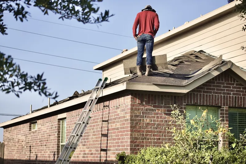 Professional roofer working on a residential roof in Country Club Village
